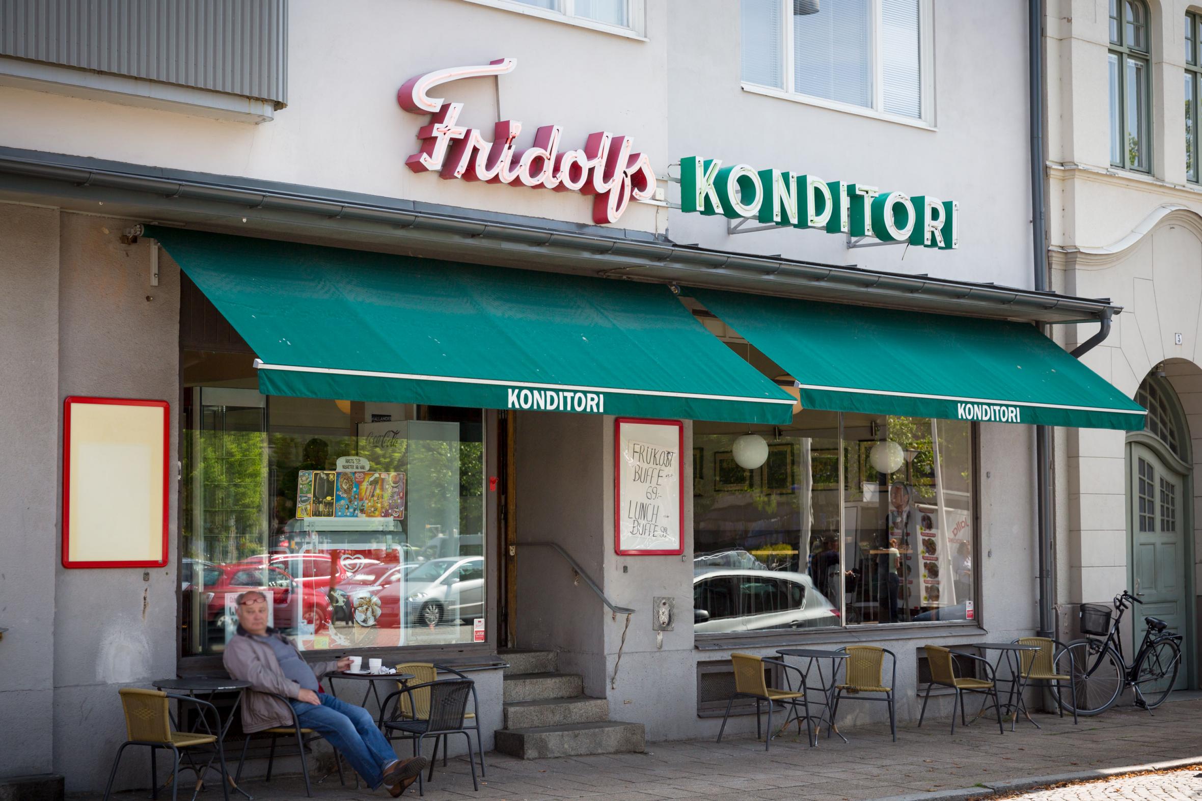 En man dricker kaffe utanför Fridolfs Konditori i Ystad