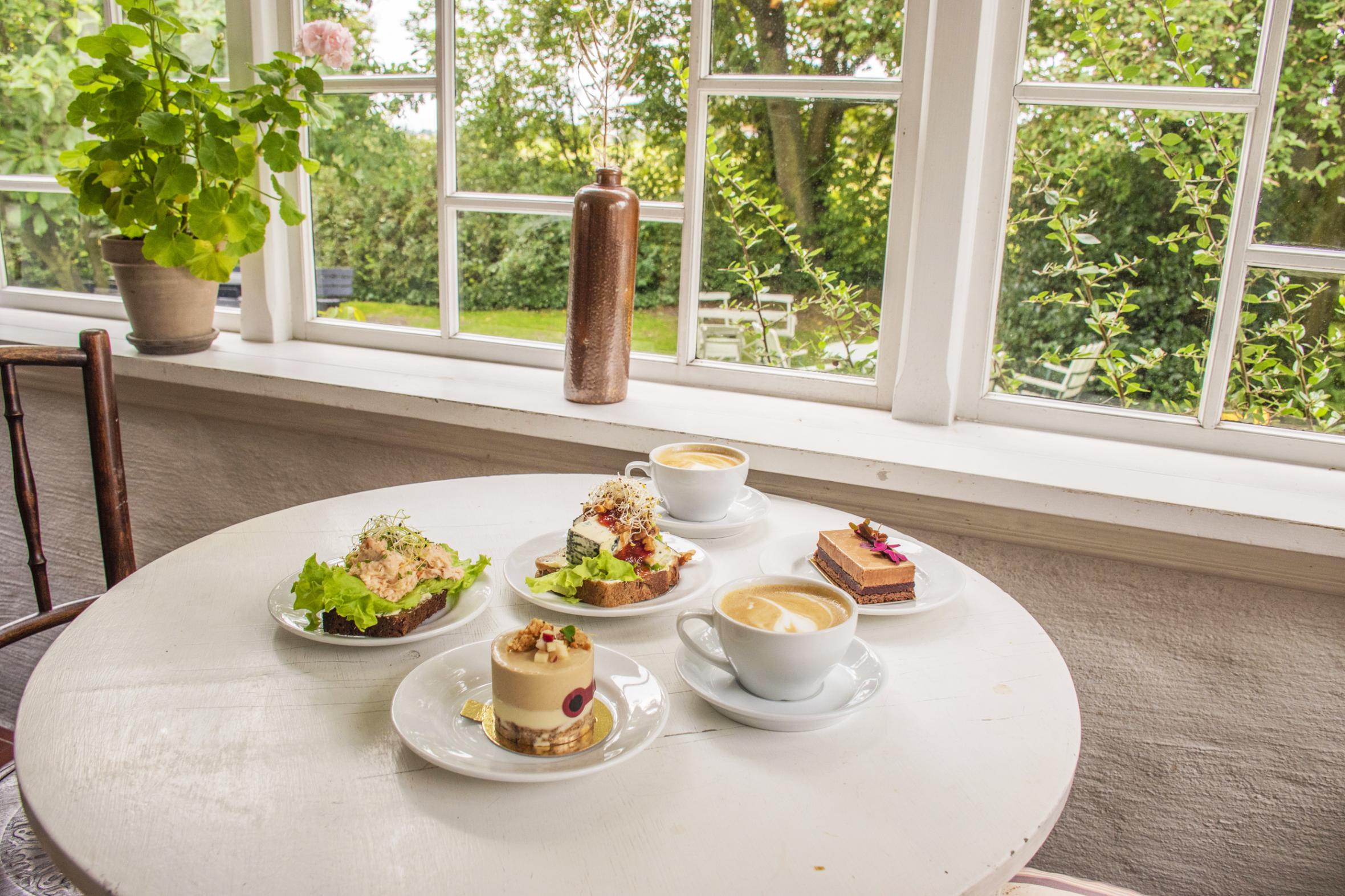 Plated pastries on a table in green garden surrounding