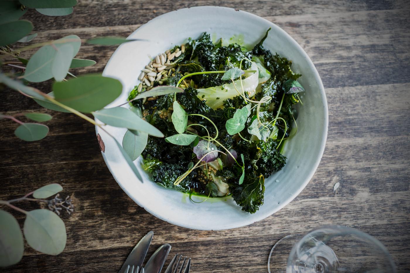 Salad in a white bowl on brown table