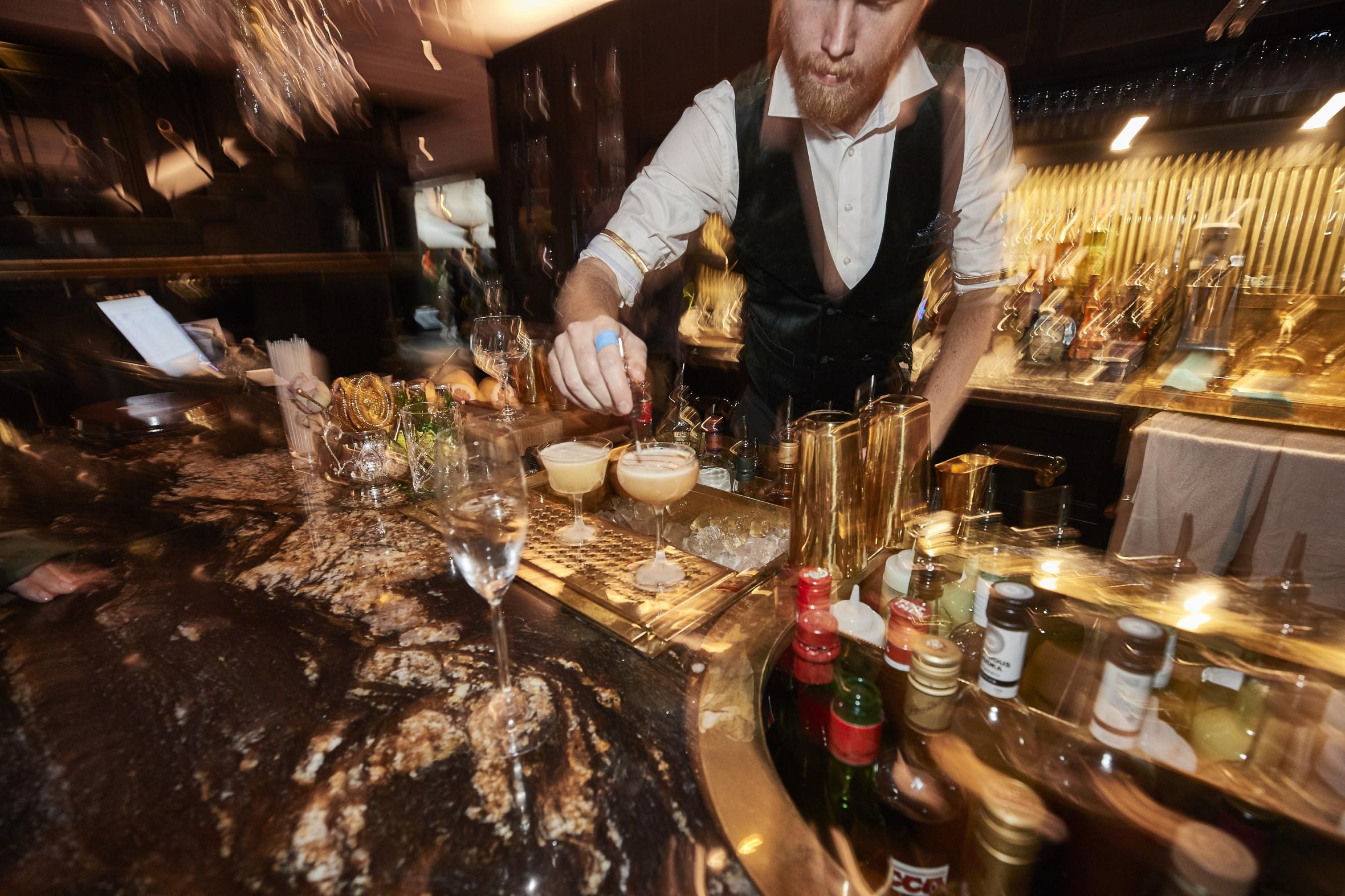 Blurry cocktail bar with bartender