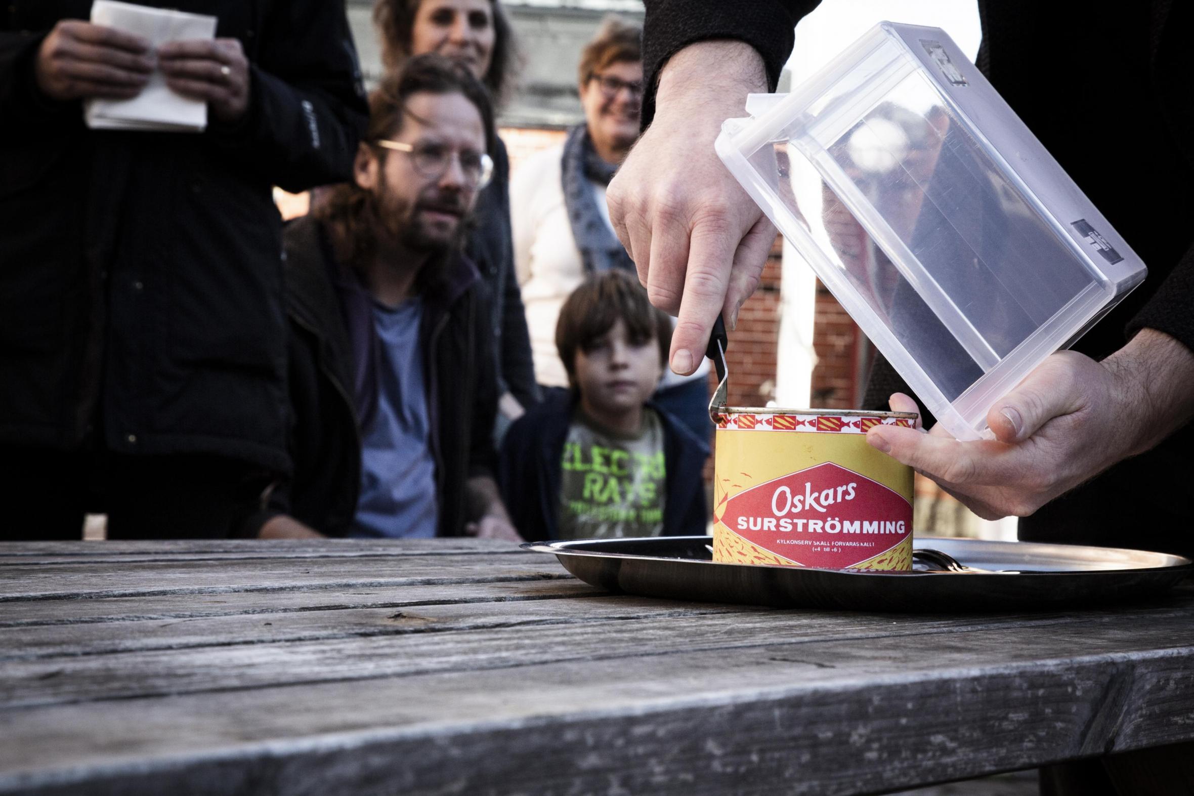 People gathered outdoors for a tasting of fermented herring  