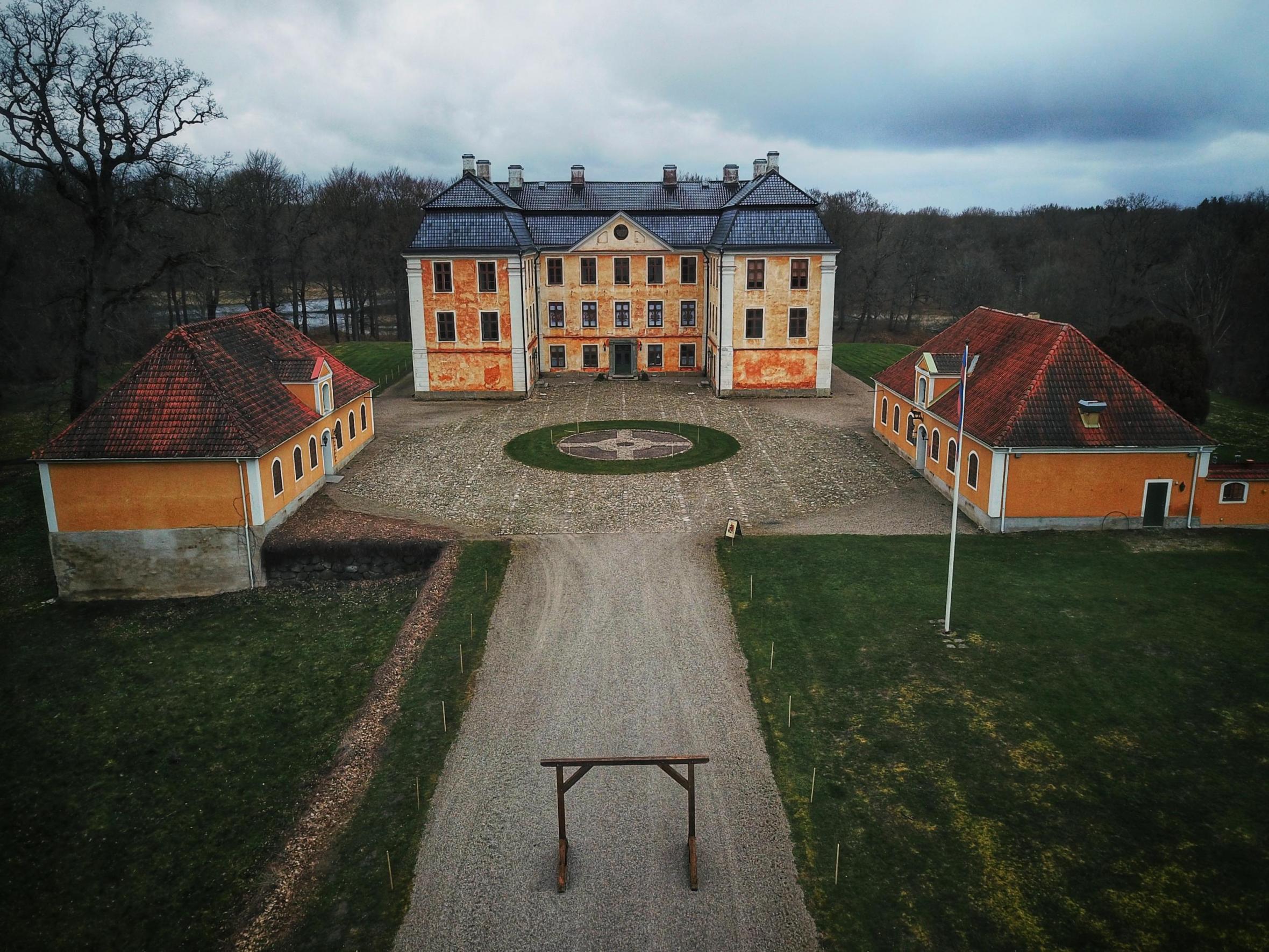Blick von oben auf das Schloss Christinehof an einem bewölkten Tag