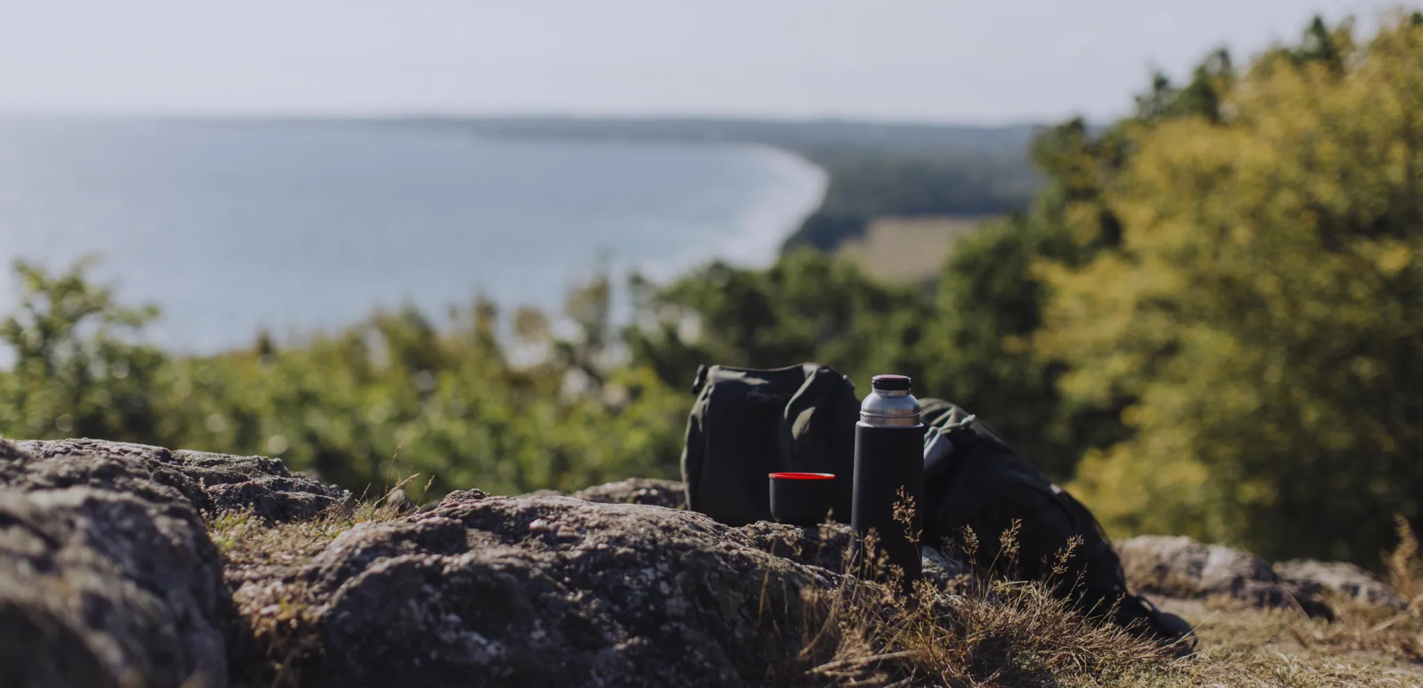 Coffee thermos on a hill by the sea