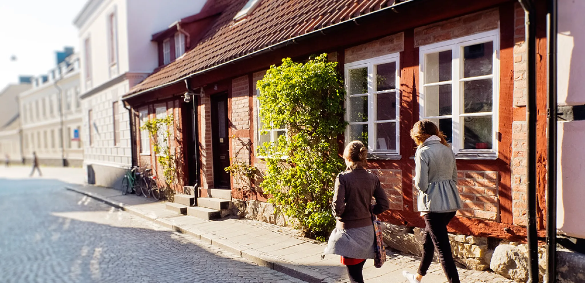 Two women walking on the cobblestone street in Lund