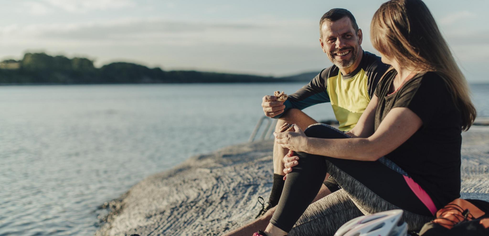 Två personer sitter vid kusten i Skåne.