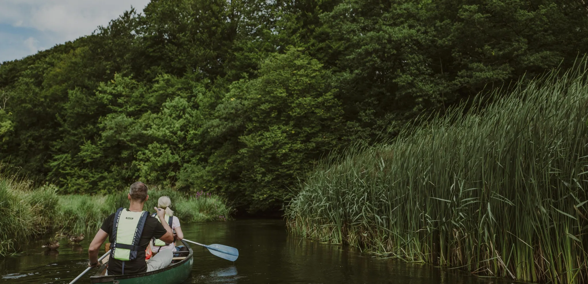 Family paddling through nature surrounding at Rönne Å 
