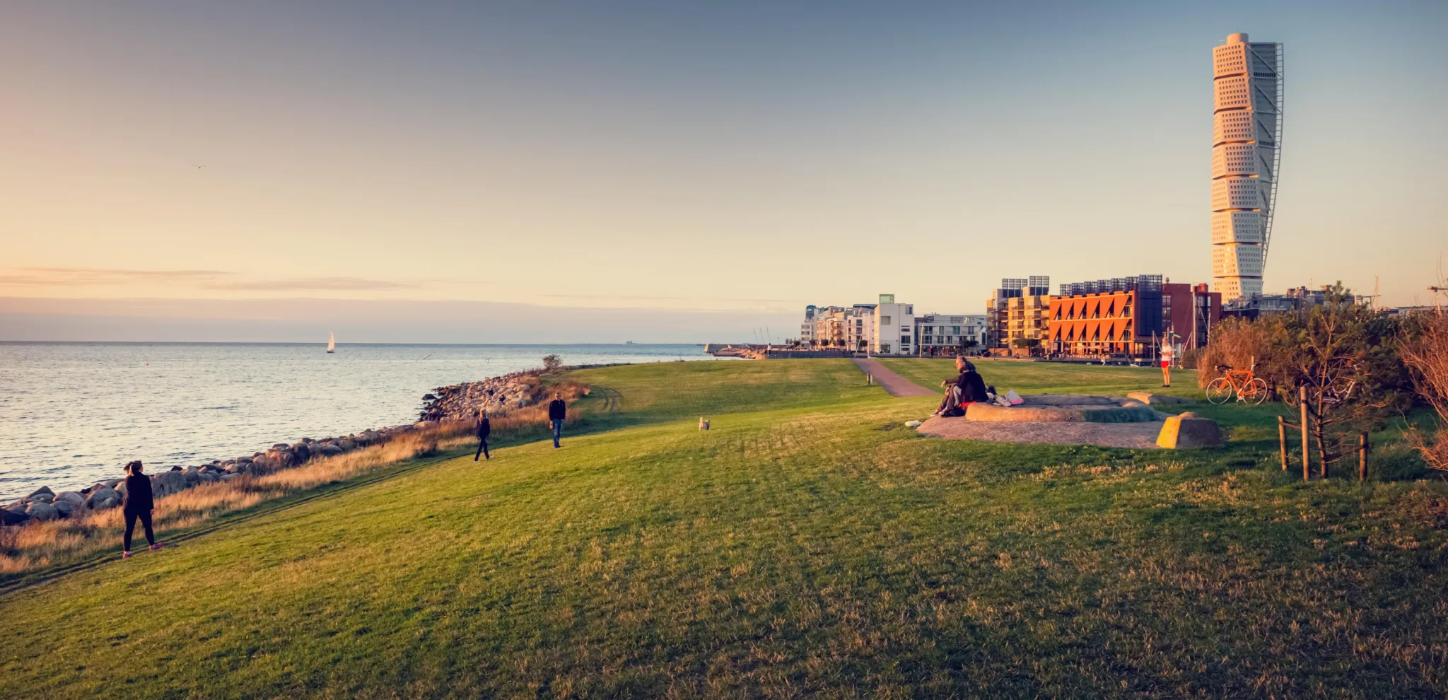 People enjoy a beautiful sunset near the turning torso 