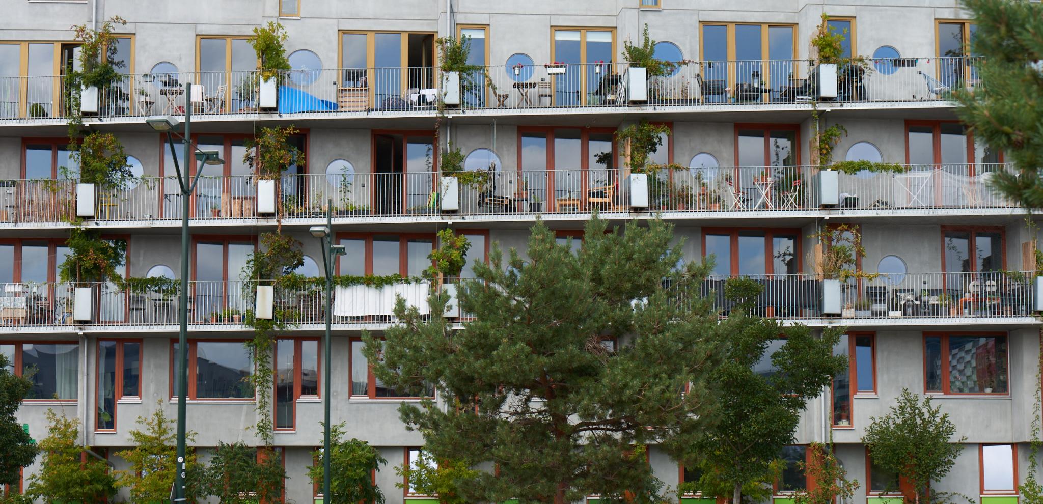 The grey exterior of the OHboy hotel in Malmö with trees in front