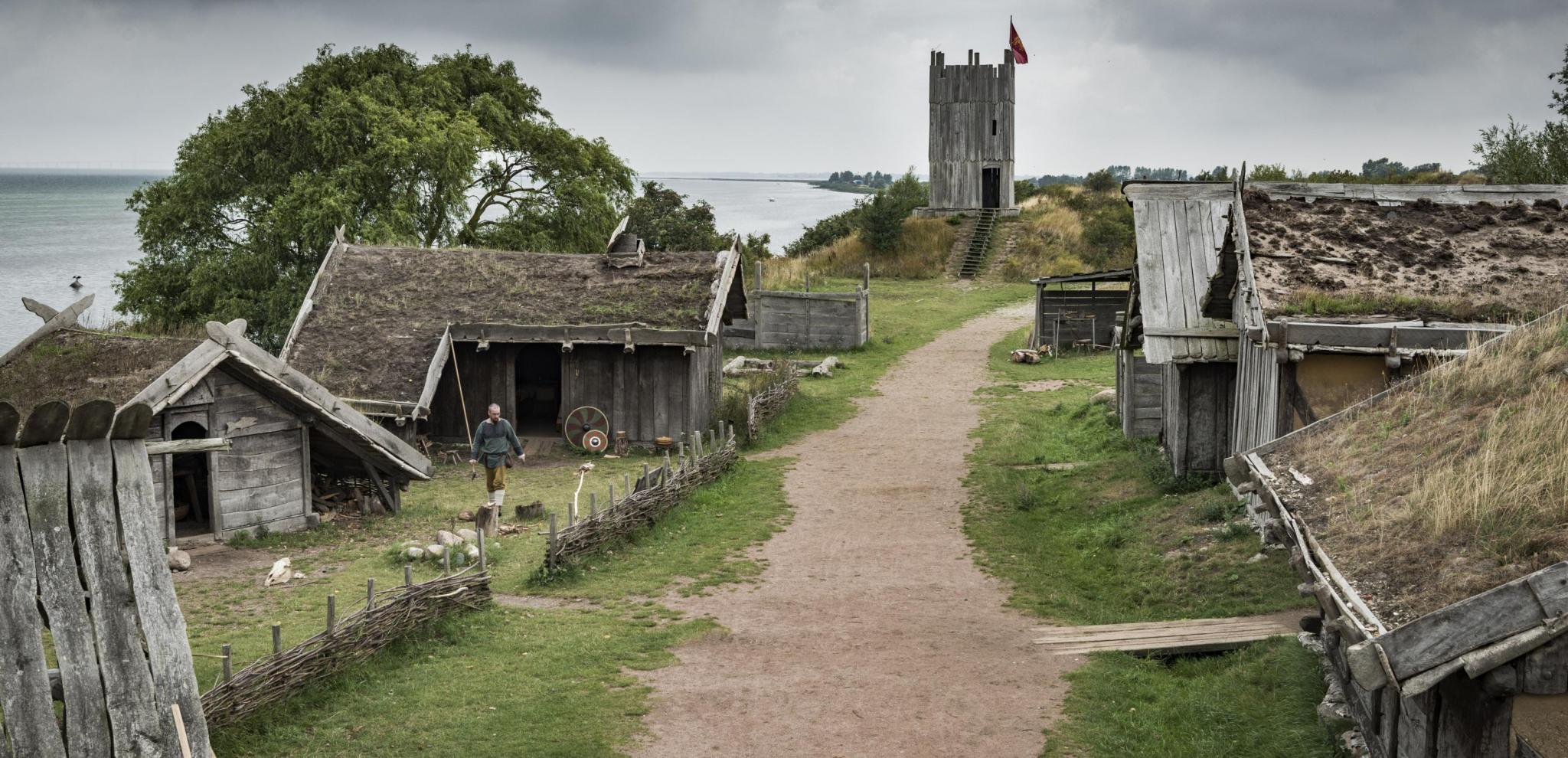 A gravel road and surrounding wooden houses in the Viking village of Fotevikens Museums