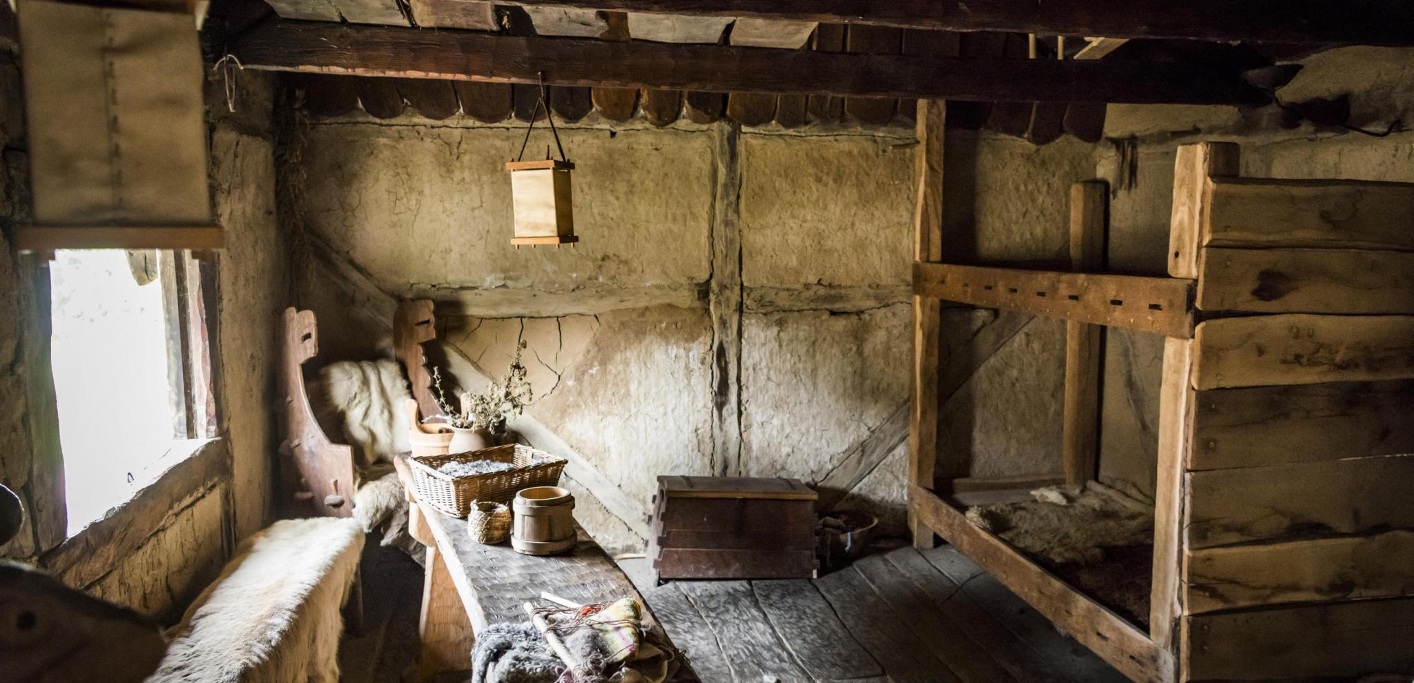 Traditionellt vikingrum med träbord och säng
