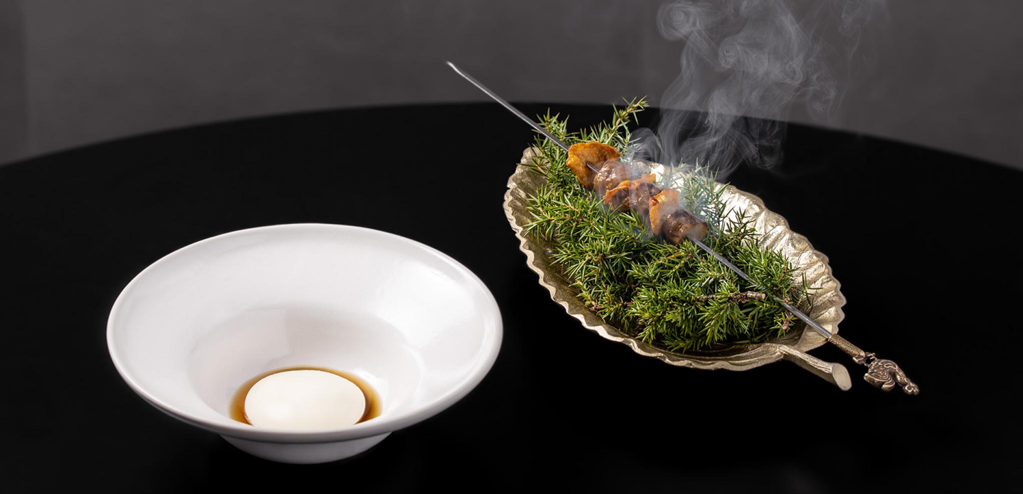 Warm food dish with white plate on black table