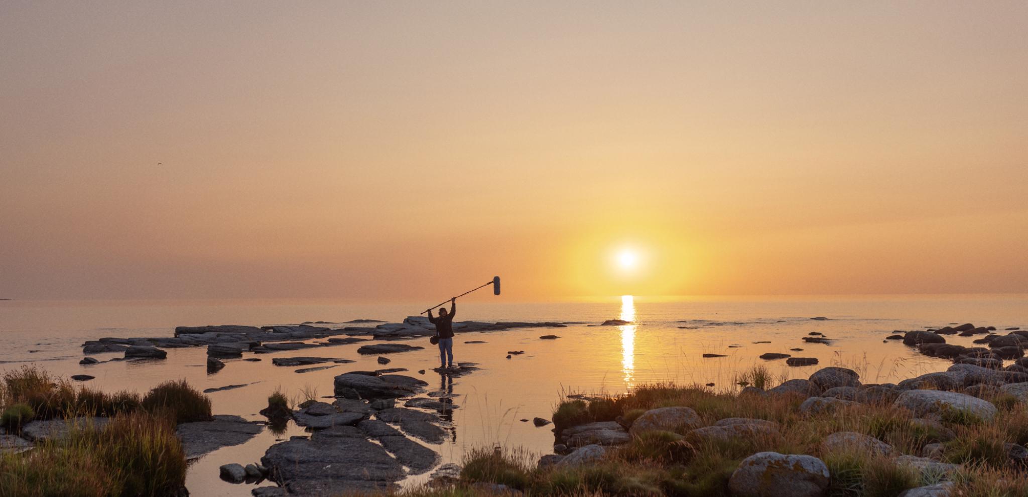 Sound engineer measuring sound by the ocean