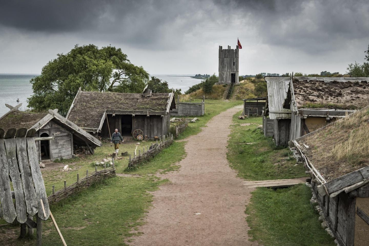 A gravel road and surrounding wooden houses in the Viking village of Fotevikens Museums