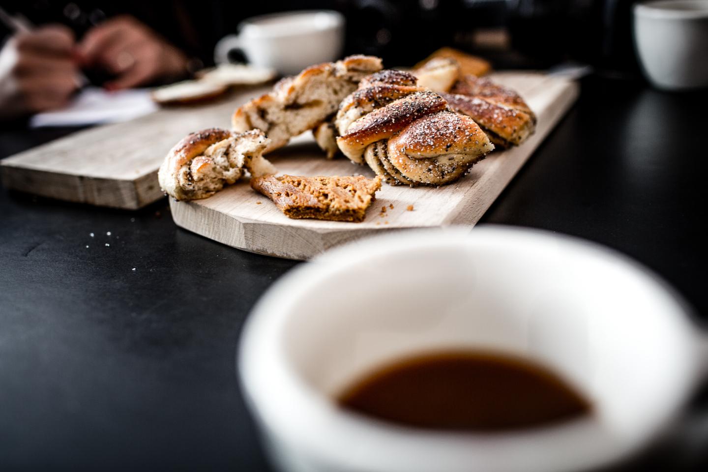 Danish pastries on wooden plank with cup of coffee
