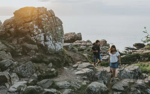 Ett par vandrar bland klipporna vid havet i hovs hallar