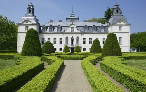 Vor dem Schloss Kronovall erstreckt sich ein Labyrinth aus Buchsbäumen.