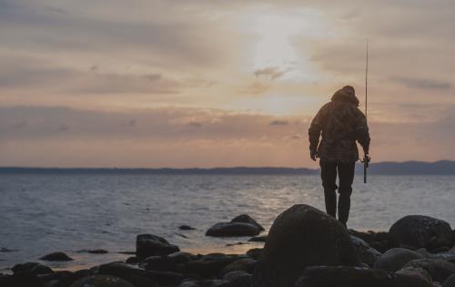 En person fiskar i solnedgången
