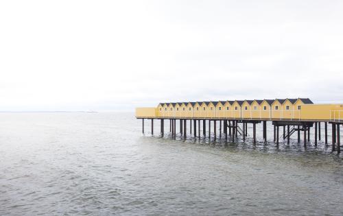 Open-air bathhouse held up by pier stilts in the sea 