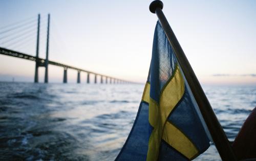 Svensk flagga framför Öresundsbron taget från havet