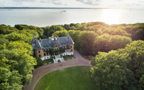 En sikt från ovan av Sofiero slott framför havet och omgiven av träd