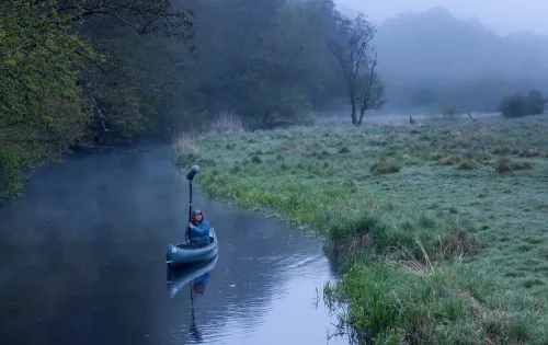 Sound guy in canoe in still Rönne river