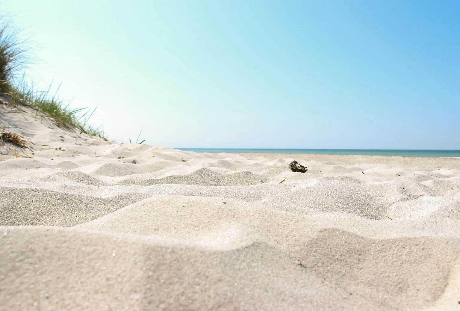En vit sandstrand i Sandahmmar på en klar sommardag