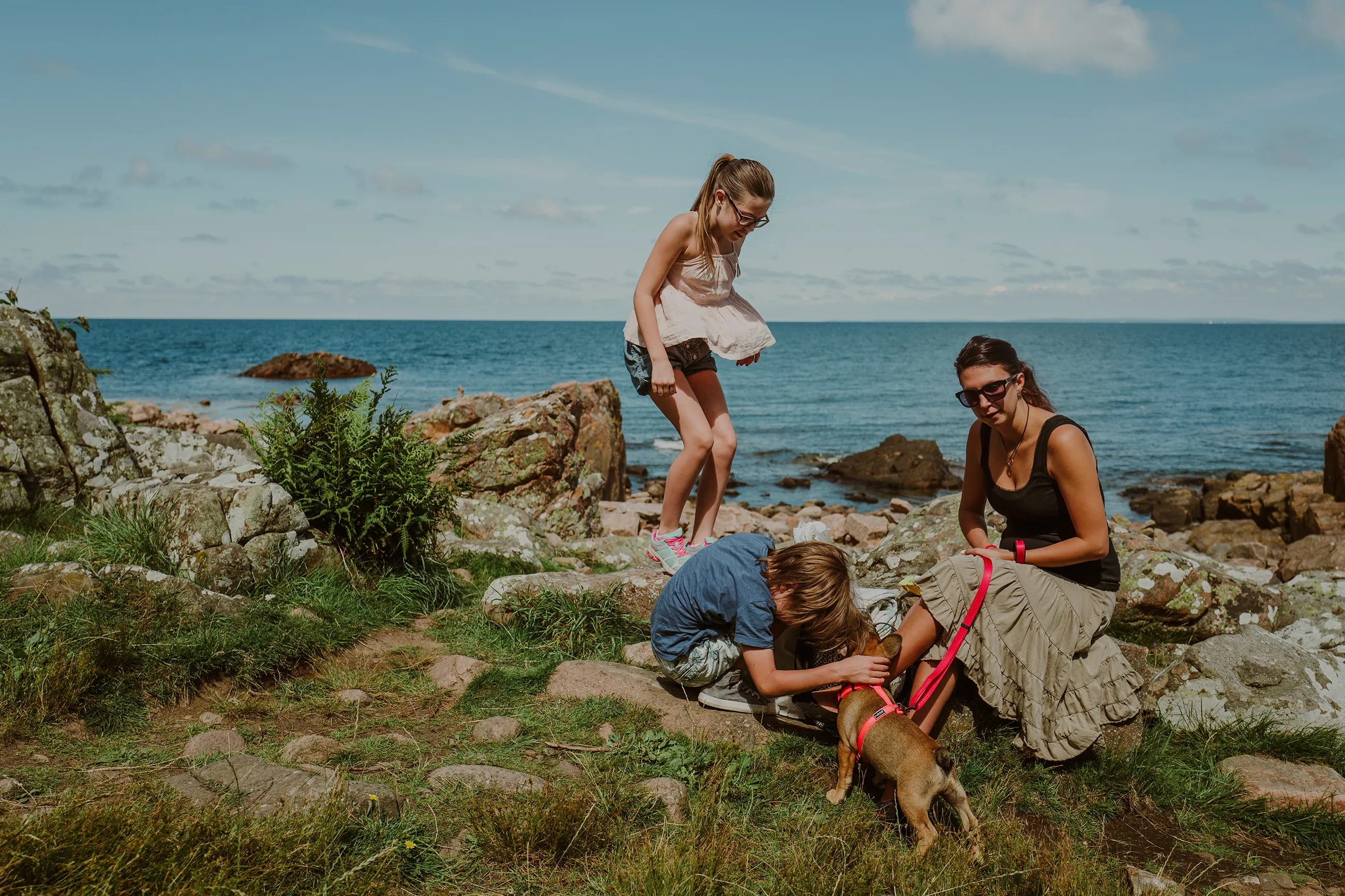 En familj på stranden med sin hund