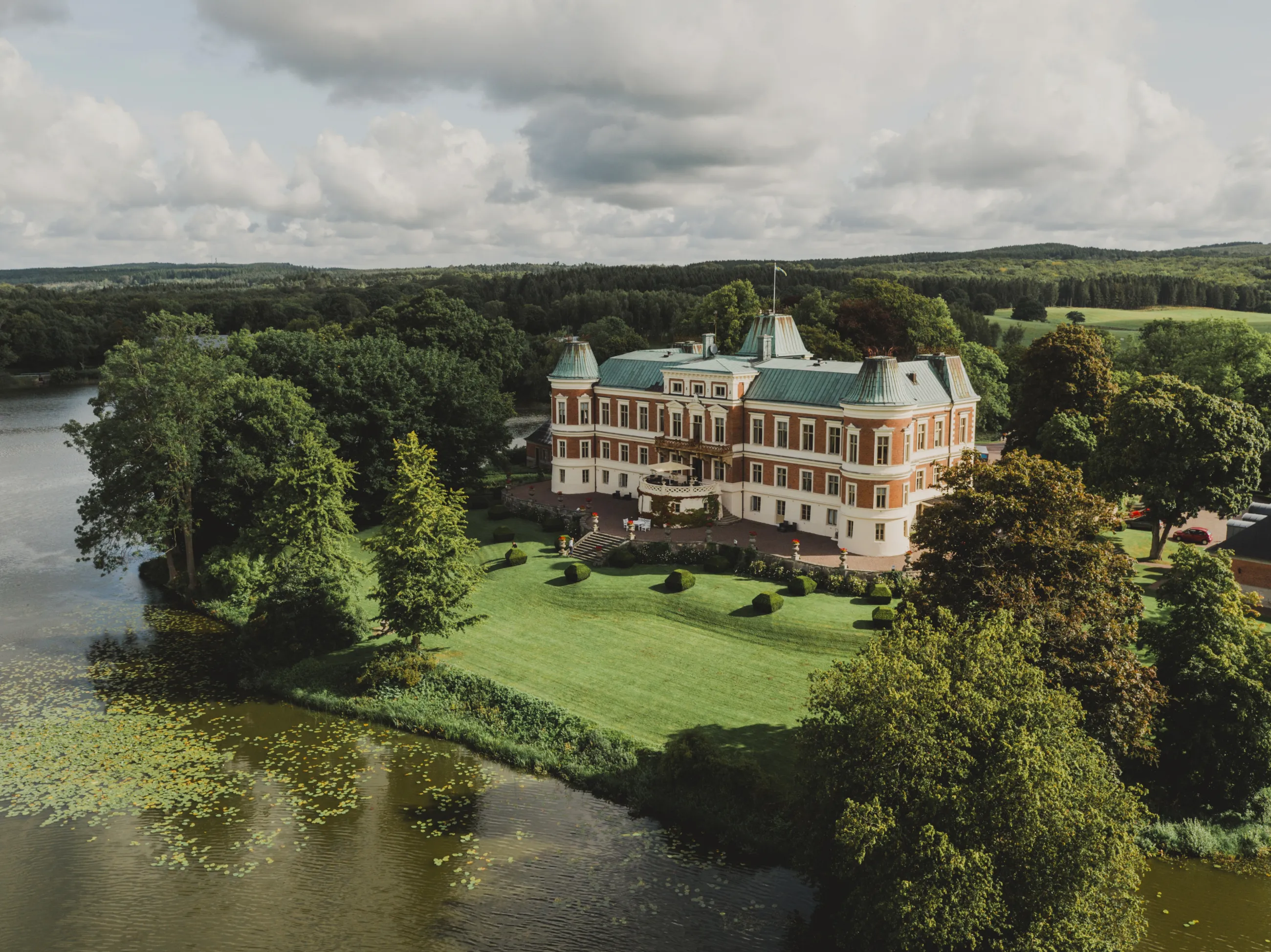 Vy från ovan av Häckeberga slott omgiven av vatten och skog