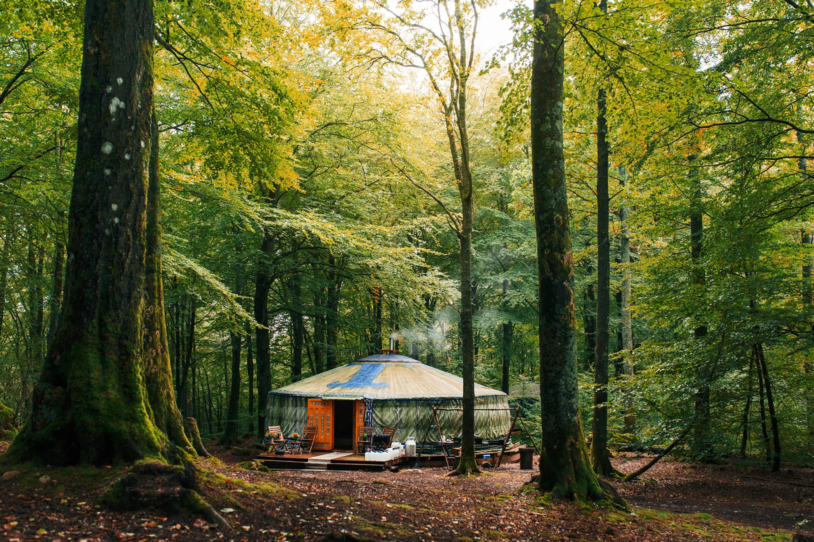 Ein großes rundes Zelt im Wald, in dem man auch essen kann.