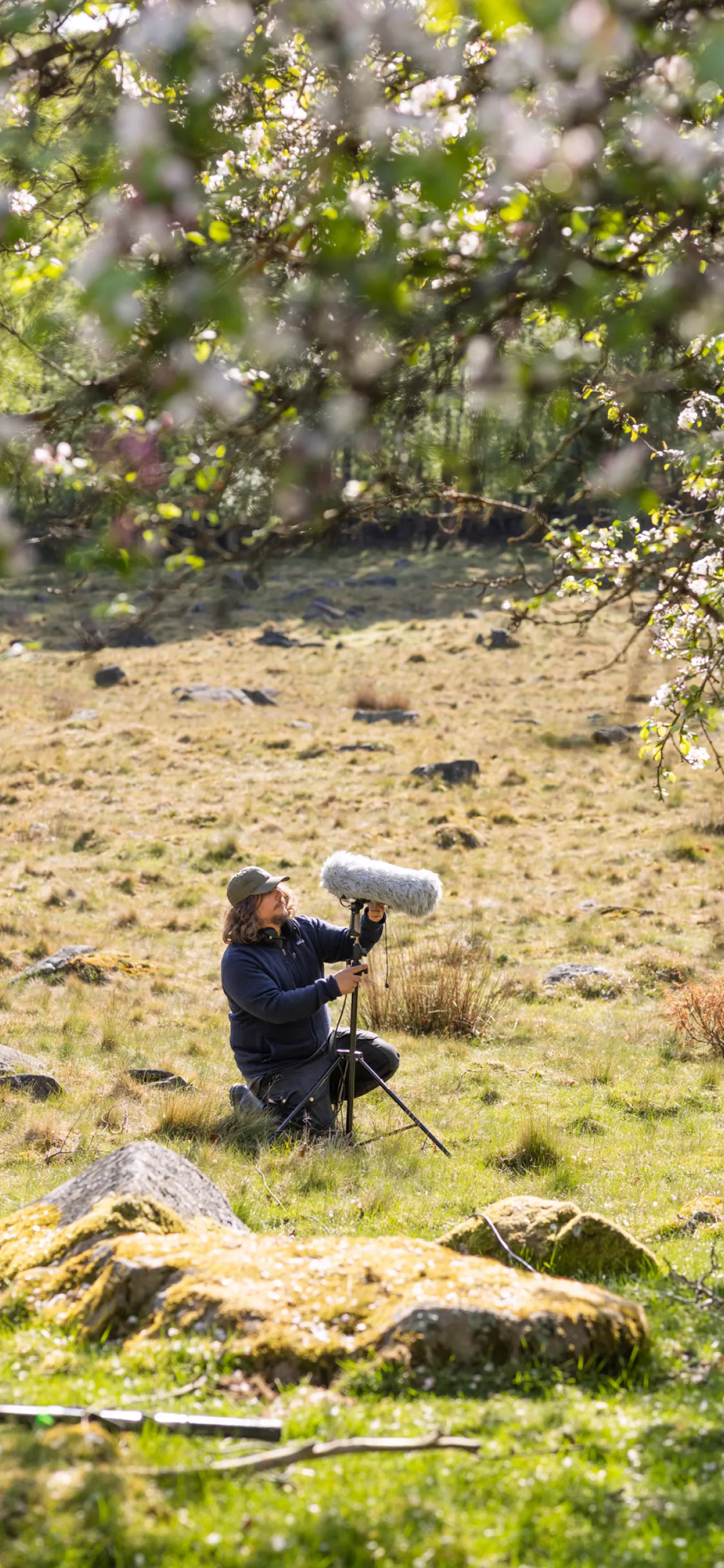 Sound guy fixing his boom pole in meadow