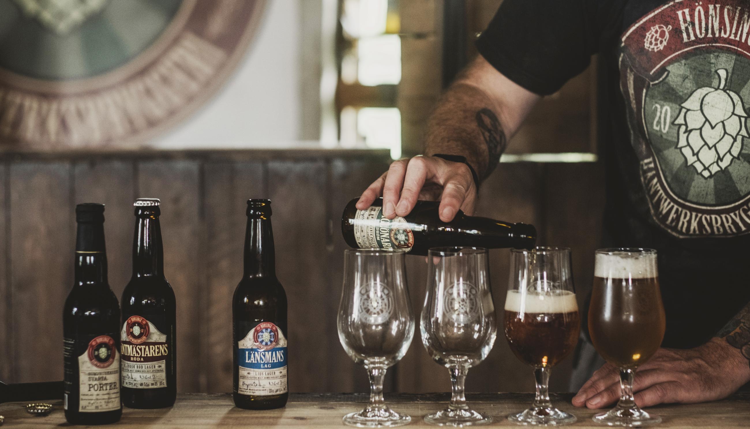 In der Brauerei Hönsinge Bryggeri schenkt ein Mann Bier in Gläser ein.