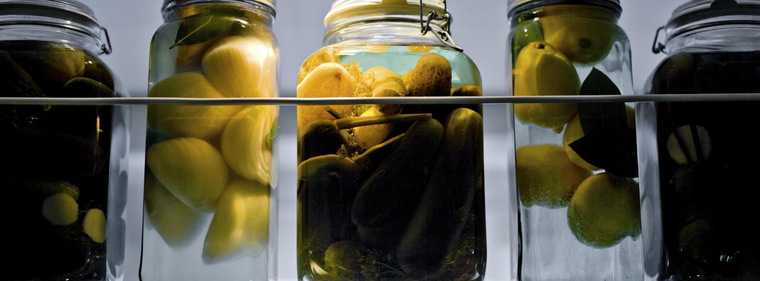 Jars of pickled vegetables in row