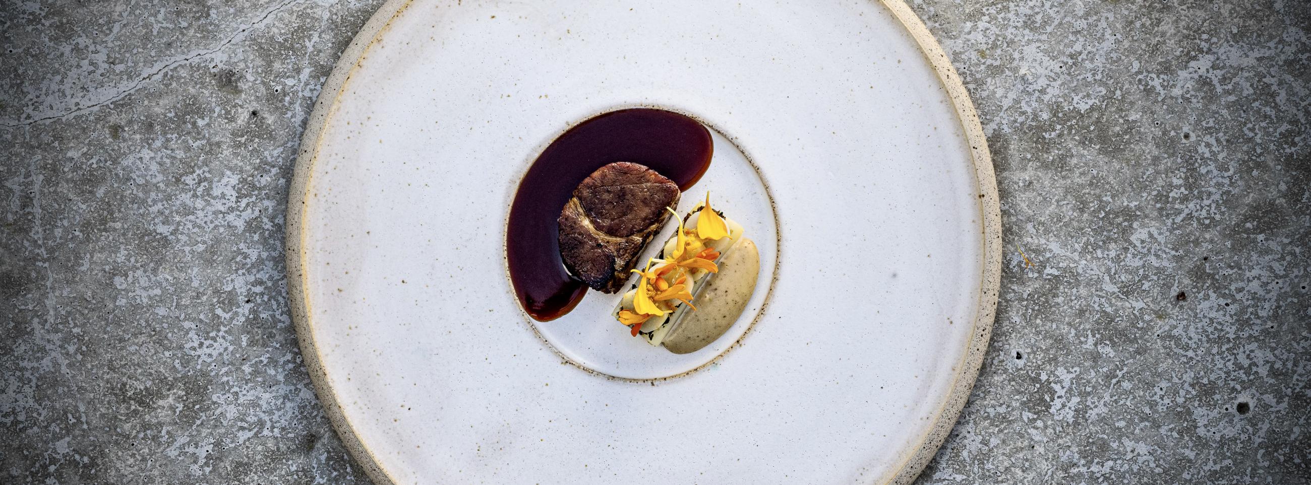 Ceramic white plate with a sophisticated meat and potato serving