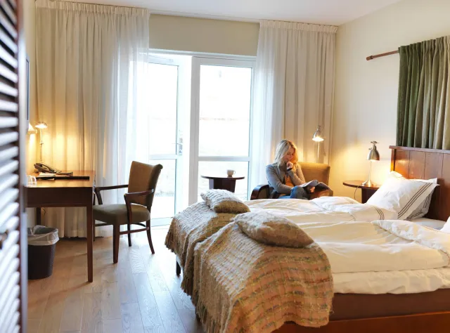 A woman reading a book in a hotell room 