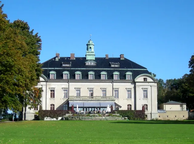 White castle with large green lawn in front and blue sky behind