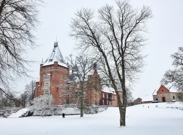 Brick castle in winter with snow on the ground and roof