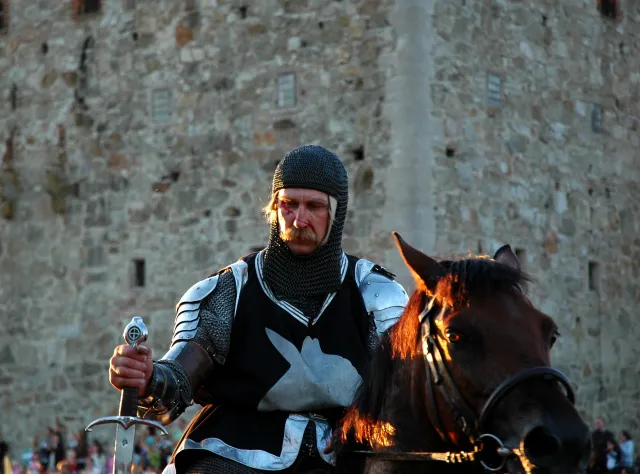 Knight on a horse with blood in his face and a sword in his hand
