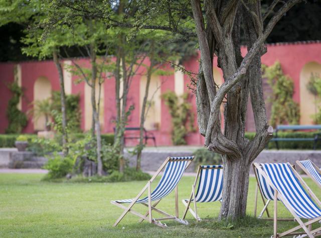 Lawn chairs surrounding a tree in the garden of Bäckaskogs castle 