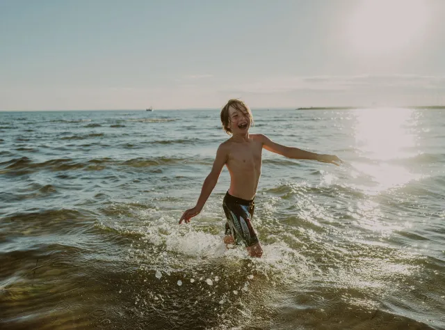 Ein Junge badet im schonischen Borstahusen im Meer.