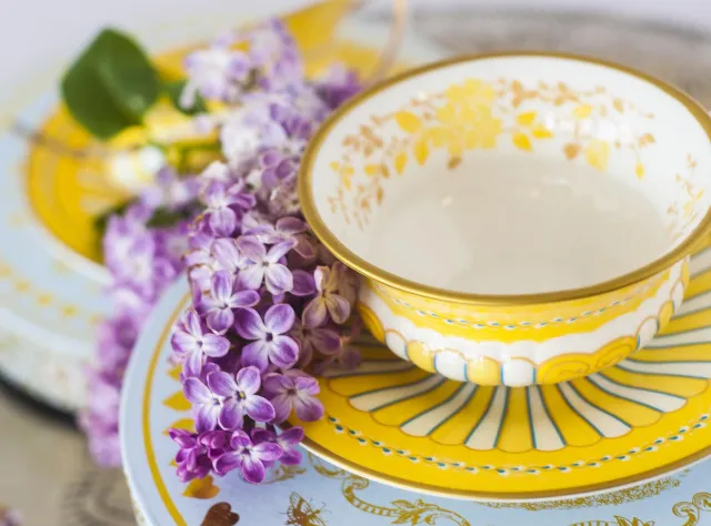 Yellow tea cup with purple flower