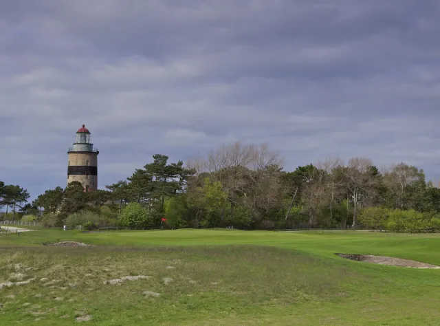 Golf course with lighthouse and a dark sky