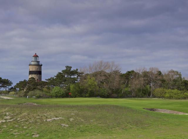 Golf course with lighthouse and a dark sky