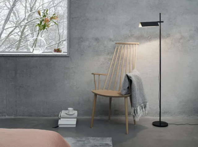 Grey room with rocking chair, blanket and a floor lamp
