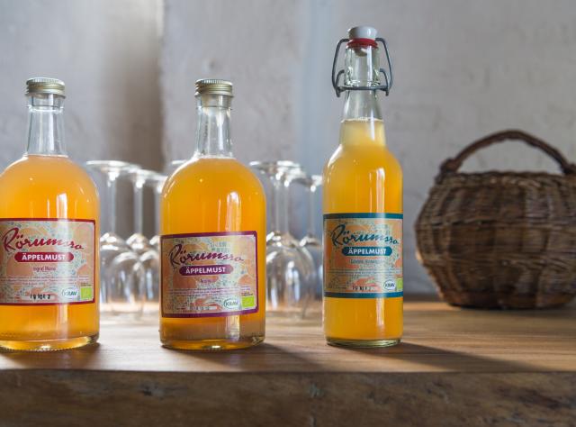 Apple juice bottles in a row with woven basket in the background