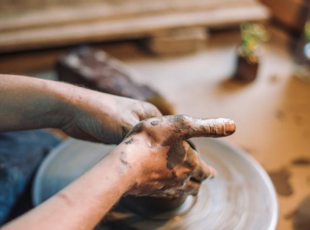Hands making pottery 