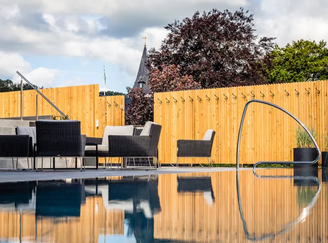 A pool area with lounge furniture.