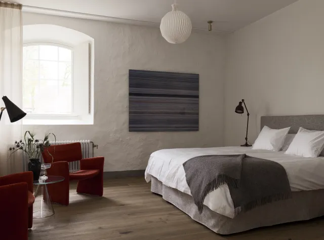 Double bed in a hotel room within a historic or older building, showcasing period architectural details