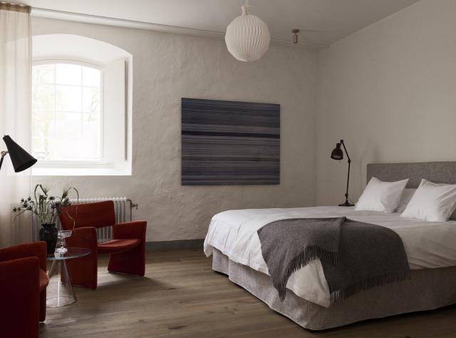Double bed in a hotel room within a historic or older building, showcasing period architectural details