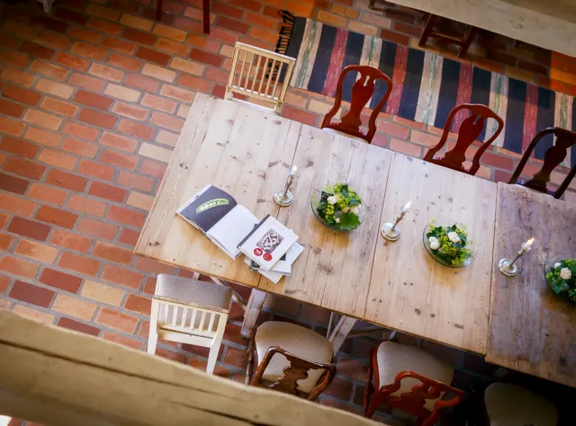 Overhead view of dining table with candlesticks and green botanical decorations