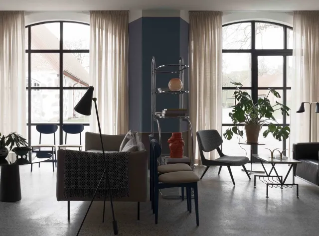 Living room featuring designer furniture with two large windows flooding the space with abundant natural light